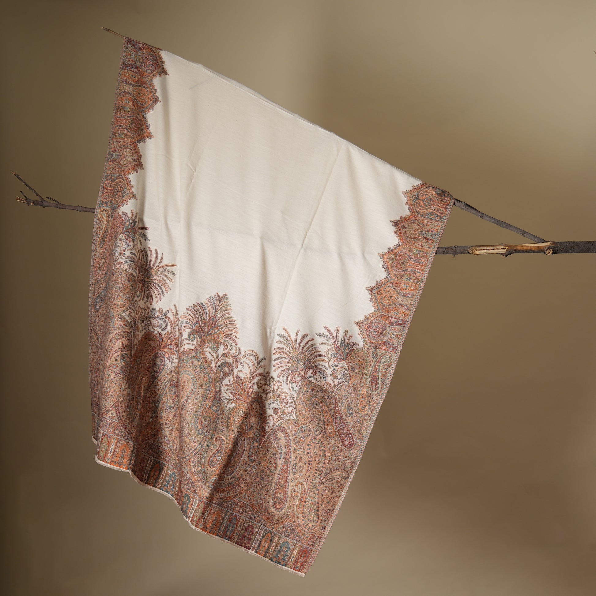 Decorative blanket with intricate patterns hanging on a stick against a beige background shop at earthandoak
